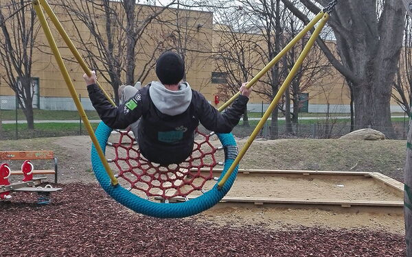 Balu-Mitarbeiter prüft die Schaukel auf einem Spielplatz