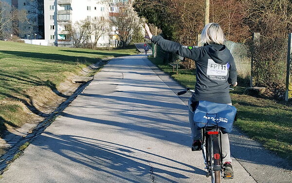 Eine FTP11-Mitarbeiterin ist auf dem Fahrrad in Simmering unterwegs.