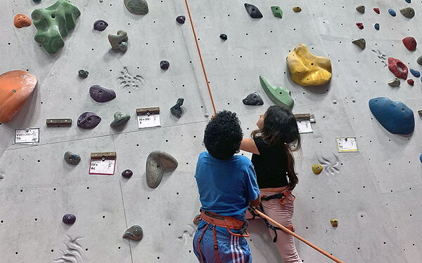 Zwei Kinder sichern beim Bouldern.