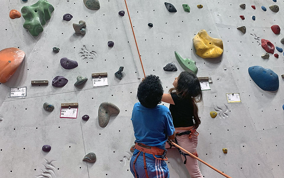 Zwei Kinder sichern beim Bouldern.